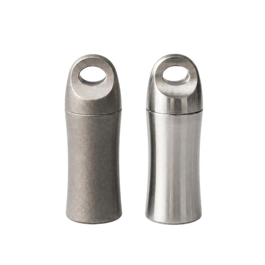 Mini titanium medicine containers, one open and one closed, silver cylindrical body