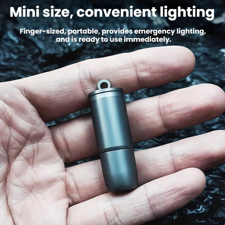 Mini keychain flashlight with top loop, dark metallic cylindrical body in open palm