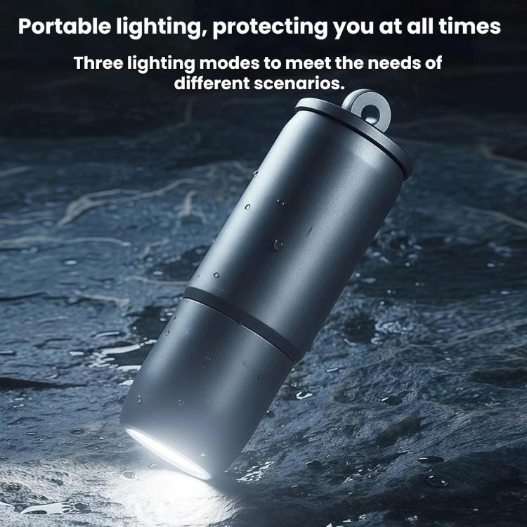 Mini metallic flashlight with key ring shining a bright beam on the ground