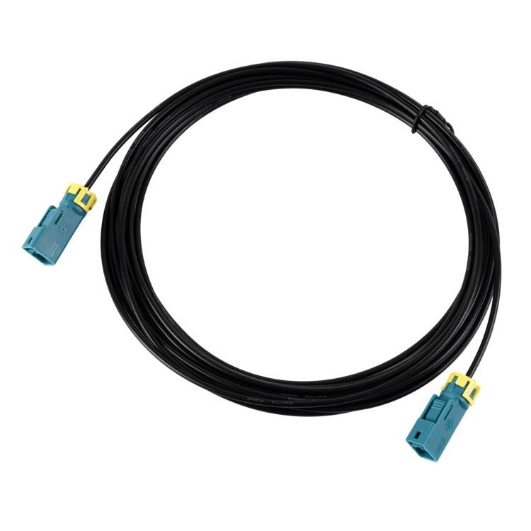 Coiled black coaxial cable with dual Fakra Z female connectors, teal housings, yellow latches.