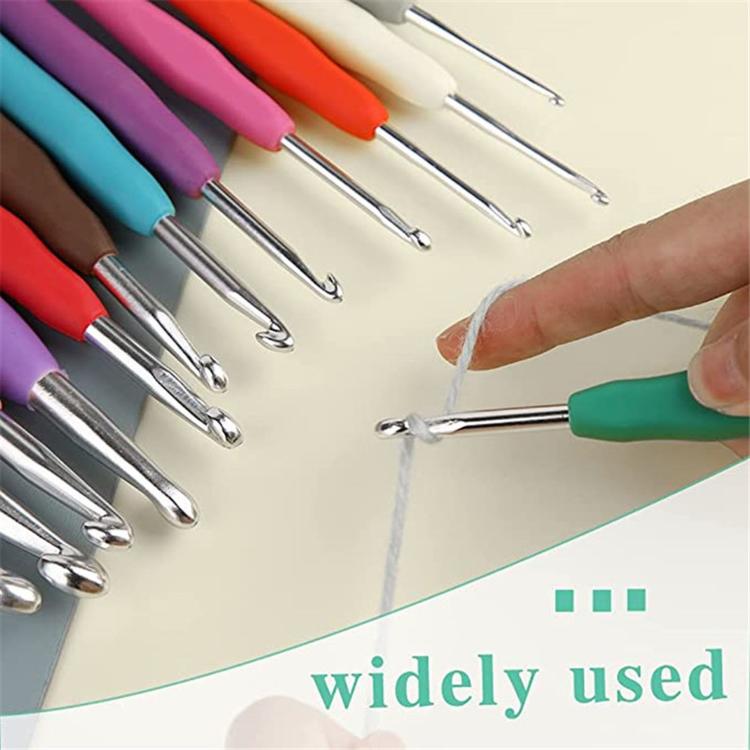 Crochet hooks set with multicolor handles, hook tip held over yarn