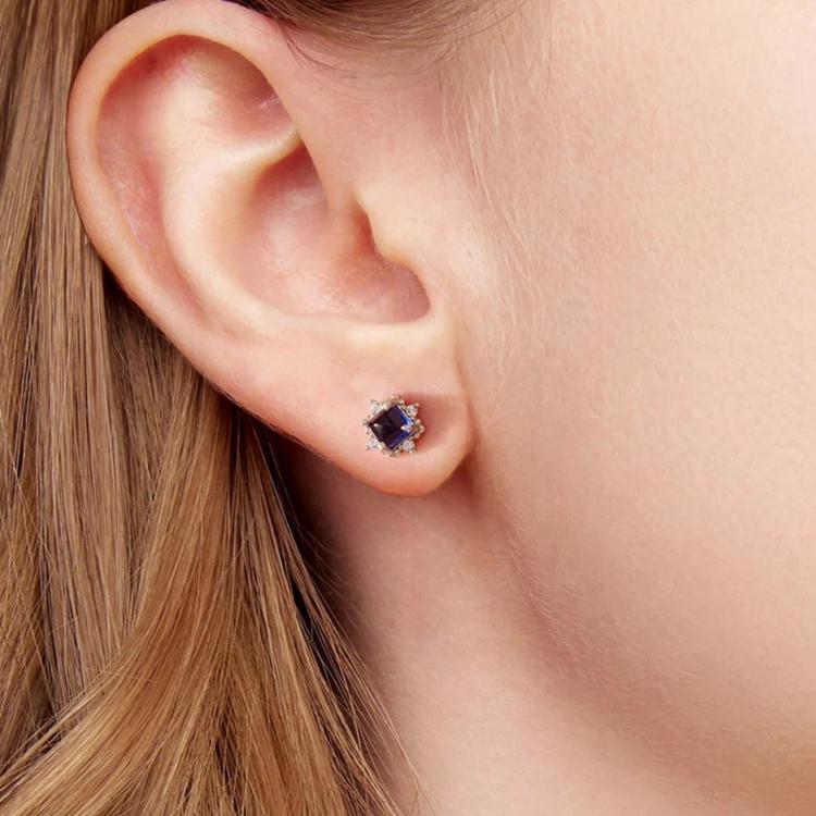 Sterling silver stud earrings with square blue stone and clear halo on ear