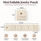 Beige mini foldable jewelry pouch with snap button and four storage compartments.