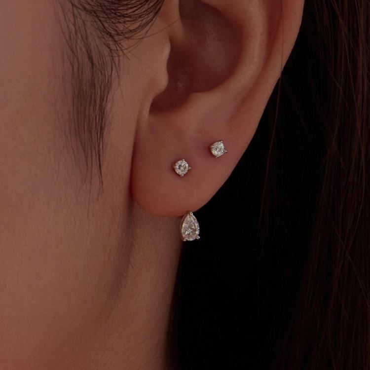 Teardrop moissanite stud drop earrings on ear, small top stone and dangling pear stone