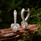 Sterling silver heart-shaped hoop earrings with dangling heart and clear stones