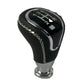 Black round gear shift knob with numbered shift display, chrome base, stitched cover