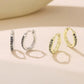 Silver- and gold-tone hoop earrings with vintage scroll pattern, side view