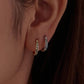 Hoop earrings worn on ear: gold- and silver-tone vintage scroll patterns