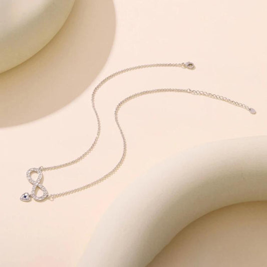 Silver-tone pendant necklace with small infinity and heart charms on chain
