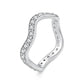 Wave-shaped silver ring with small prong-set moissanite stones along the raised band