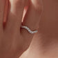Slim wave moissanite ring on finger with sparkling stones along the curved band