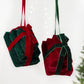 Pair of velvet gift box hanging ornaments: dark green with red ribbon, and wine red with green.