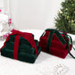 Two velvet gift box ornaments: dark green box with wine red ribbon, and wine red with green.