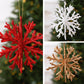 Glitter snowflake ornaments in red, white, and gold with hanging strings