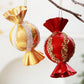 Hanging red and gold candy-shaped Christmas ornaments with jeweled glitter trim