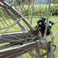 Bicycle disc brake bracket installed on fork, black metal with mounting bolts