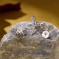 Sterling silver bat stud earrings with purple heart-shaped center on stone