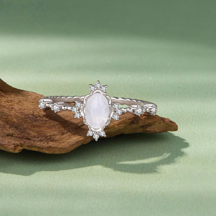 S925 sterling silver moonstone ring on wood with oval pale stone and small diamond-like details