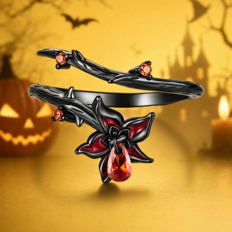 Open black gothic ring with red bow flower center and two amber side stones