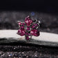 Gothic devil flower charm with magenta enamel petals and pink crystals, side view