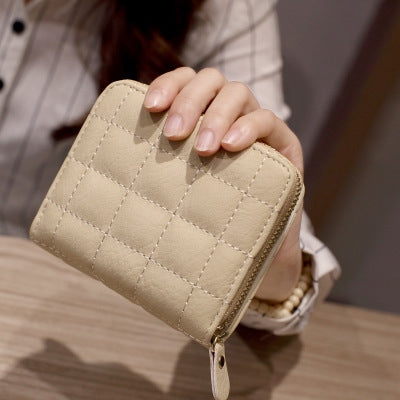 Beige quilted mini coin purse with short zipper and gold-tone zipper pull