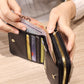 Black quilted coin purse open to show card slots and zipper closure