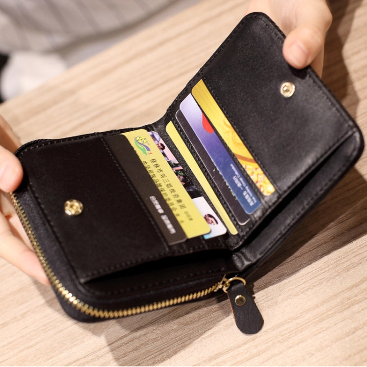 Black quilted mini wallet open with card slots, zipper closure, and keychain loop