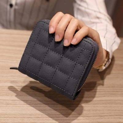 Dark grey quilted mini coin purse with short zipper and gold-tone zipper pull