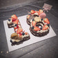Two decorated number cakes with strawberries, blueberries, and whipped cream frosting