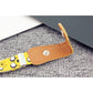 Children's elastic belt close-up: tan snap tab with silver rivet on yellow cartoon strap.