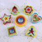 Set of 5 colorful plastic cookie plunger molds shaped like tree, star, heart, and flower