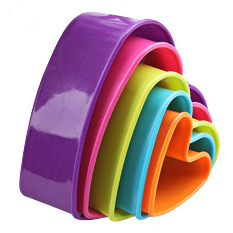Stacked plastic cookie plunger molds in purple, pink, yellow, teal, and orange layers