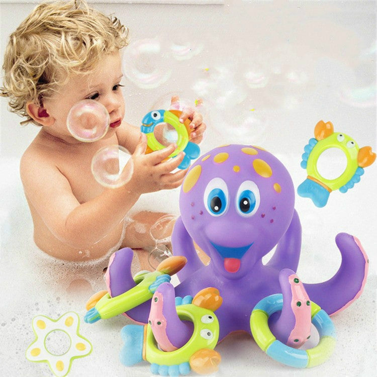 Toddler playing with purple octopus bath water toy and green ring launcher