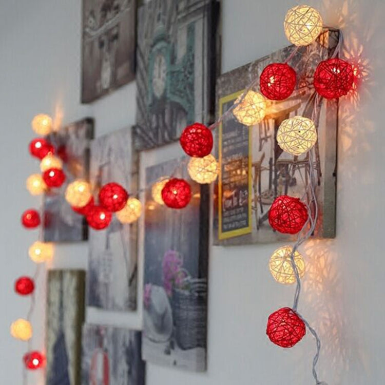 Colorful LED rattan ball string lights hanging on a wall, glowing.