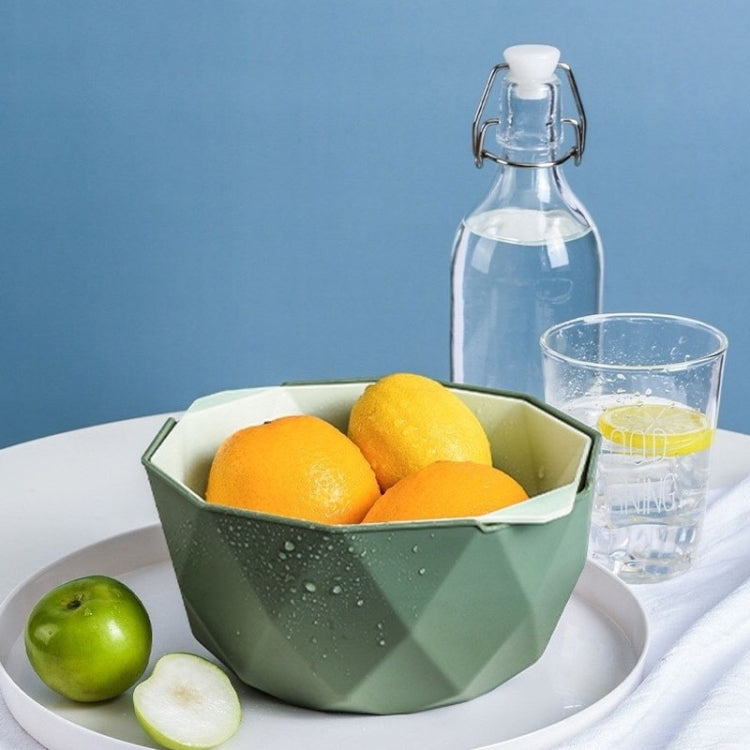 Green double-layer drain basket on tray with apples and citrus, perforated bottom