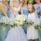 Artificial baby's breath wedding bouquets held by women and a child, white blooms
