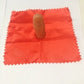 Rubber thumb tip on red cloth square, shown on tabletop