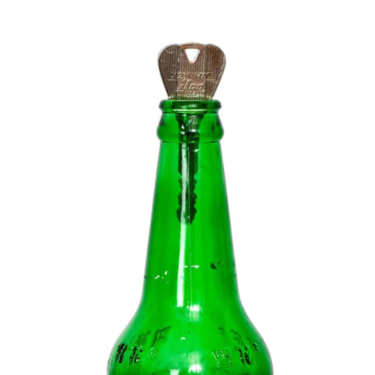 Metal magic key inserted into top of green glass bottle prop