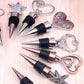 Set of metal wine stoppers with starfish, heart, and ring charms
