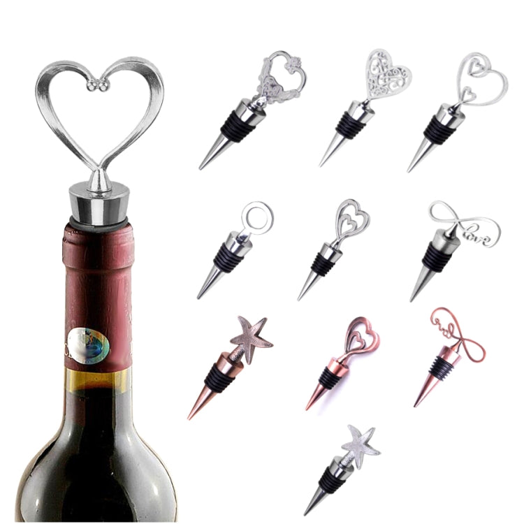 Metal wine stopper set with heart and starfish charms, shown with wine bottle