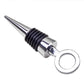 Metal wine stopper with circular loop handle, black ribbed collar, silver finish.