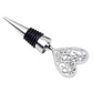 Metal wine stopper with ornate heart-shaped handle, black ribbed collar, silver finish.