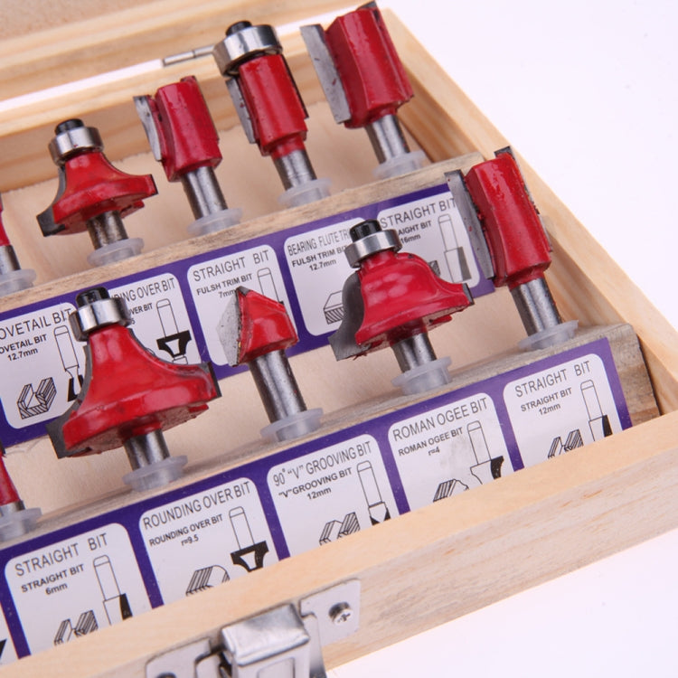 Assorted red router bits arranged in wooden case with labeled guides