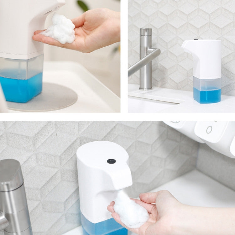 Wall-mounted automatic foam soap dispenser with blue reservoir, foamy soap in hand