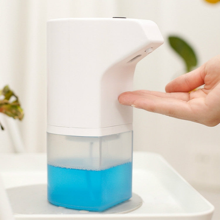 Wall-mounted automatic foam soap dispenser with blue reservoir on sink edge