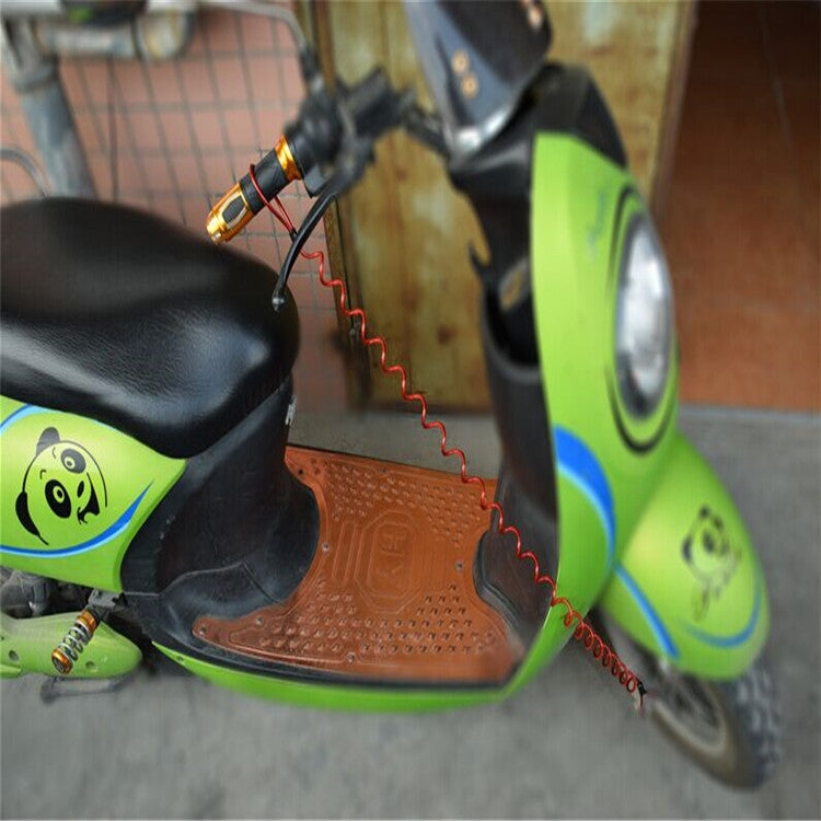 Alarm disc lock cable attached near motorbike footboard and wheel, with red coil
