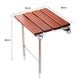 Folding wall-mounted shower chair with reddish-brown wood slatted seat and caster feet