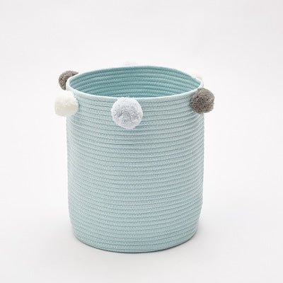 Light blue fabric storage basket with pom-pom handles and round top rim