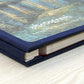 Blue fabric photo album with visible spine and stacked pages, close-up