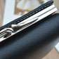 Black folding coin purse wallet close-up with textured finish and metal kiss-lock frame